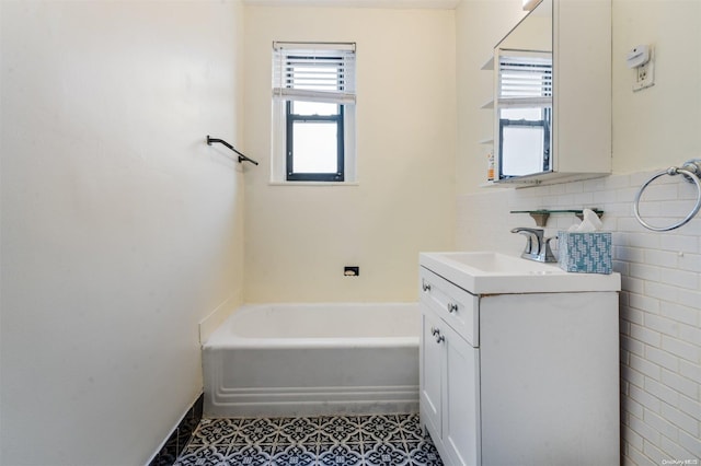 bathroom featuring vanity, tasteful backsplash, tile patterned floors, and a bathing tub