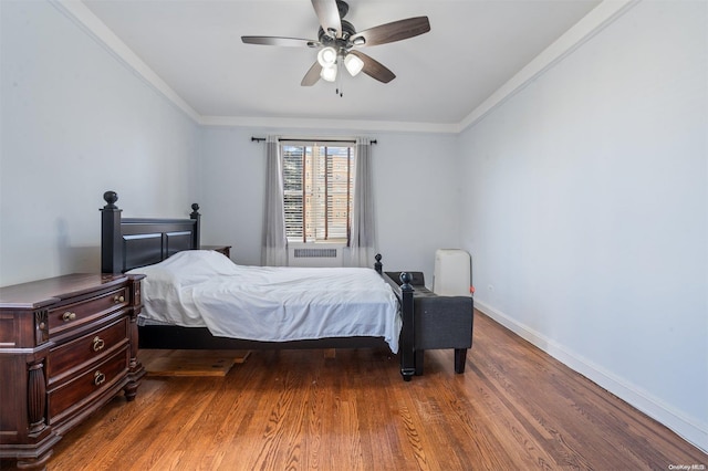 bedroom featuring ceiling fan, dark hardwood / wood-style flooring, crown molding, and radiator