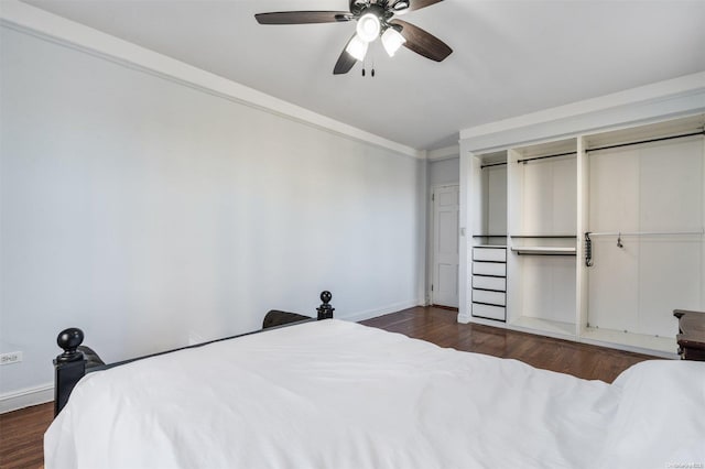 bedroom with ceiling fan, ornamental molding, dark wood-type flooring, and a closet