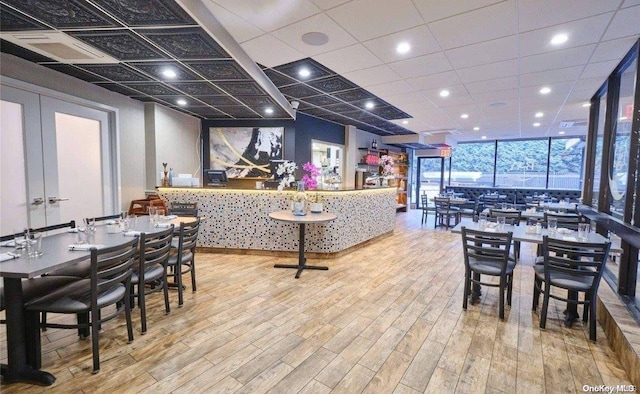 dining room with floor to ceiling windows and light hardwood / wood-style floors