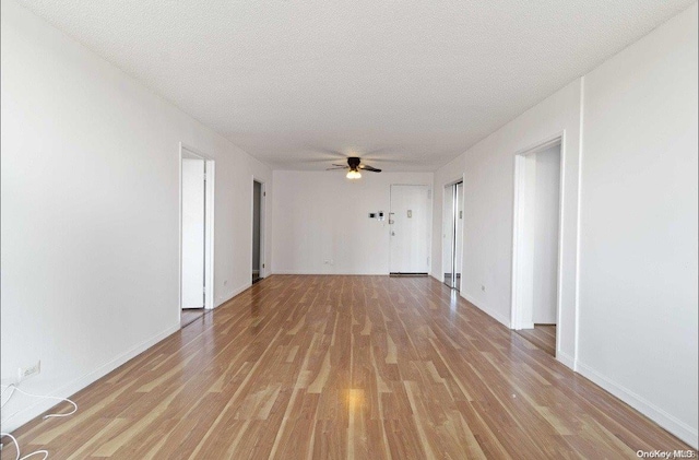 unfurnished room featuring a textured ceiling, light hardwood / wood-style flooring, and ceiling fan