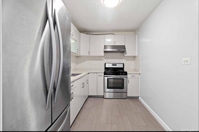 kitchen with white cabinets, a textured ceiling, and appliances with stainless steel finishes