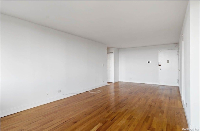 unfurnished room with wood-type flooring