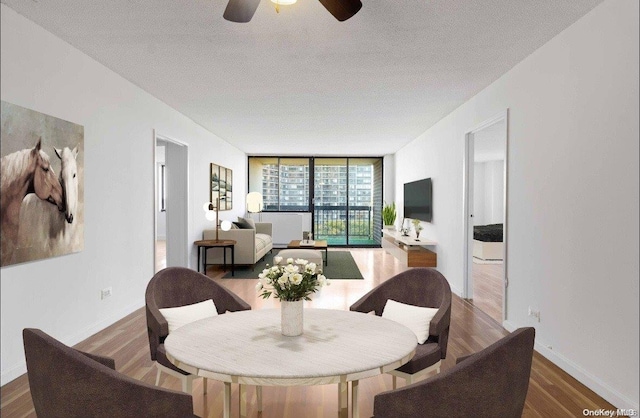 dining area with a textured ceiling, hardwood / wood-style flooring, and floor to ceiling windows