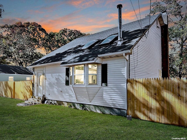 back house at dusk with a yard