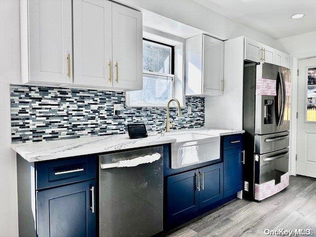 kitchen with blue cabinetry, sink, white cabinetry, and stainless steel appliances