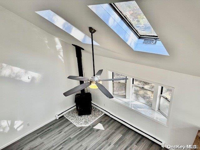 details with a skylight, hardwood / wood-style flooring, and baseboard heating