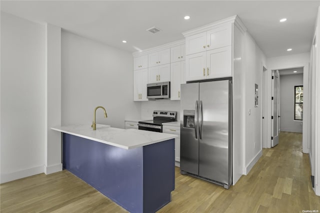 kitchen with kitchen peninsula, light wood-type flooring, stainless steel appliances, sink, and white cabinetry