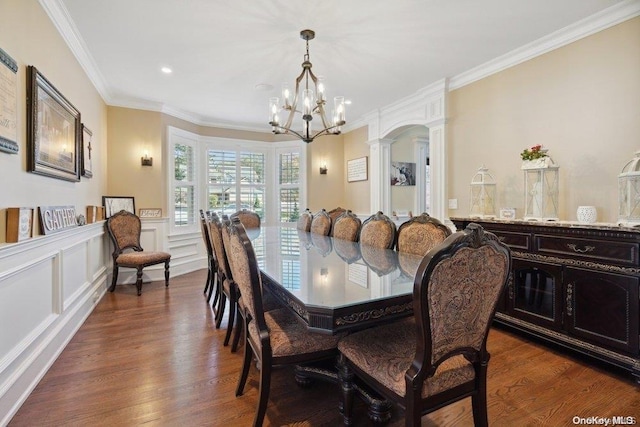 dining area featuring a chandelier, decorative columns, dark hardwood / wood-style floors, and ornamental molding