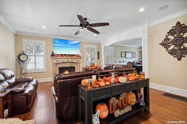 living room featuring hardwood / wood-style floors, ornate columns, ceiling fan, and crown molding