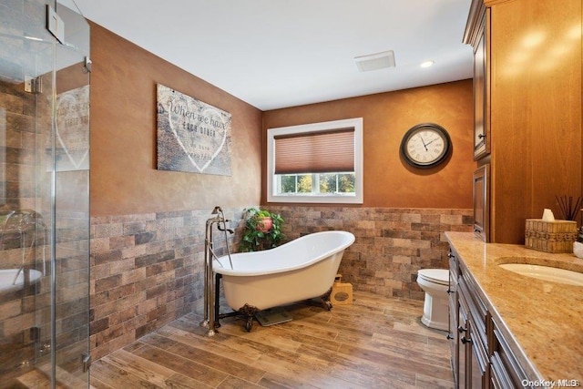 full bathroom featuring hardwood / wood-style floors, vanity, separate shower and tub, toilet, and tile walls