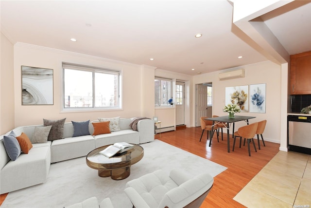 living room with a wall mounted air conditioner, light hardwood / wood-style floors, crown molding, and a baseboard heating unit