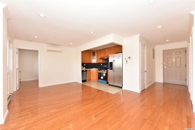 kitchen featuring stainless steel appliances, a wall mounted air conditioner, backsplash, and light hardwood / wood-style floors