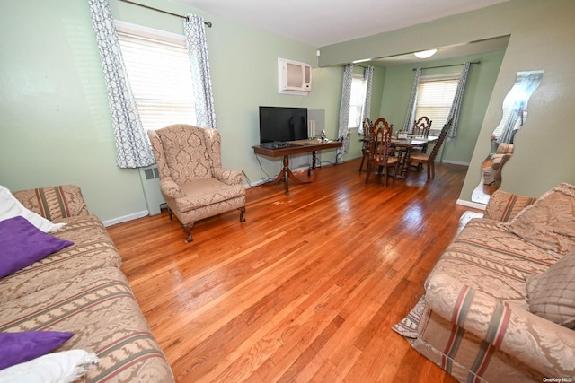 living room with hardwood / wood-style flooring and an AC wall unit