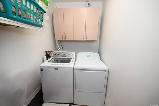 laundry area featuring washer and dryer and cabinets