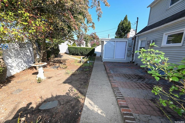 view of yard featuring a patio and a shed