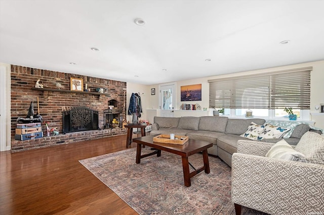 living room with a fireplace and wood-type flooring