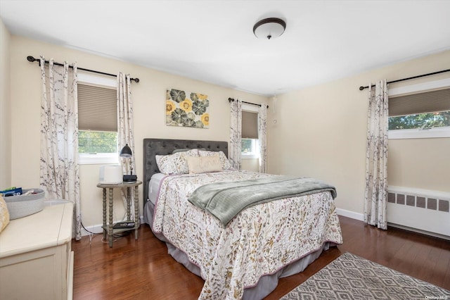 bedroom with dark hardwood / wood-style flooring and radiator