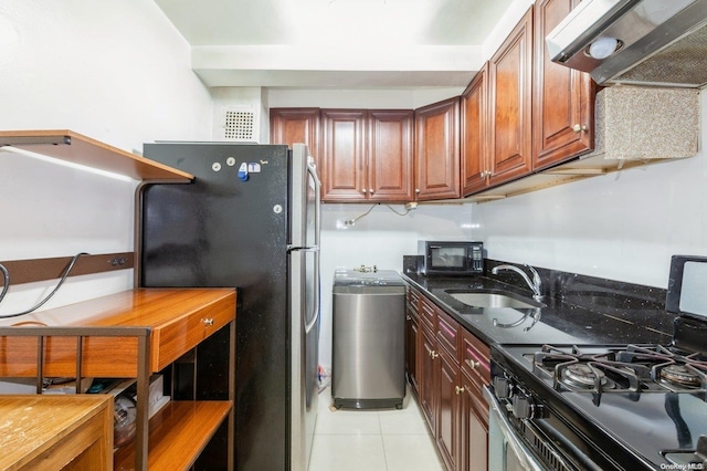 kitchen featuring sink, stainless steel appliances, dark stone counters, extractor fan, and light tile patterned floors