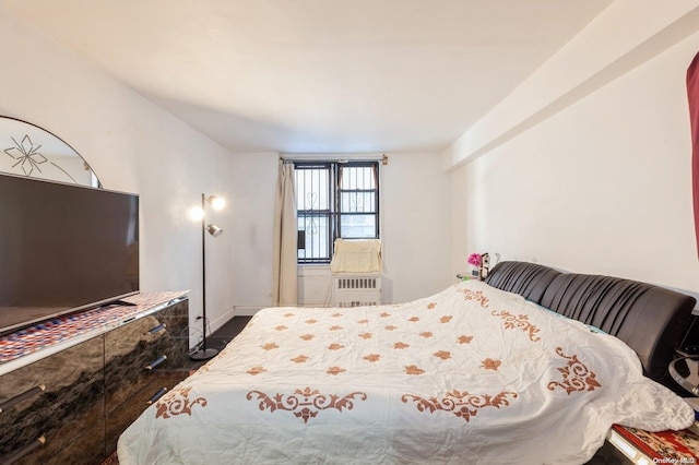 bedroom featuring radiator heating unit and dark hardwood / wood-style flooring