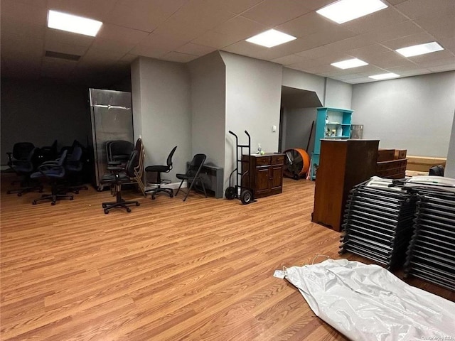 misc room with a paneled ceiling and light hardwood / wood-style floors