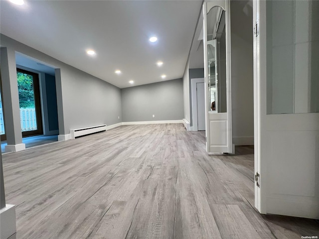 unfurnished living room with light wood-type flooring and baseboard heating