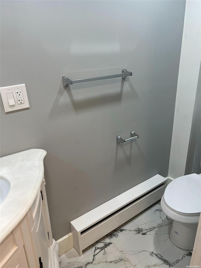 bathroom with vanity, toilet, and a baseboard heating unit