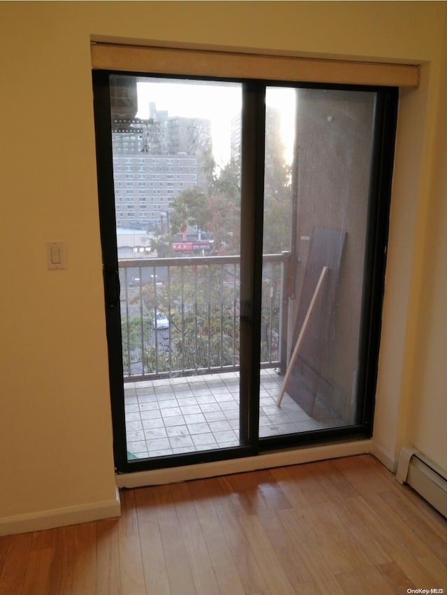 43-20 Union St Unit 6D, Flushing, NY 11355 - doorway to outside with a baseboard radiator, wood finished floors, healthy amount of natural light, and baseboards