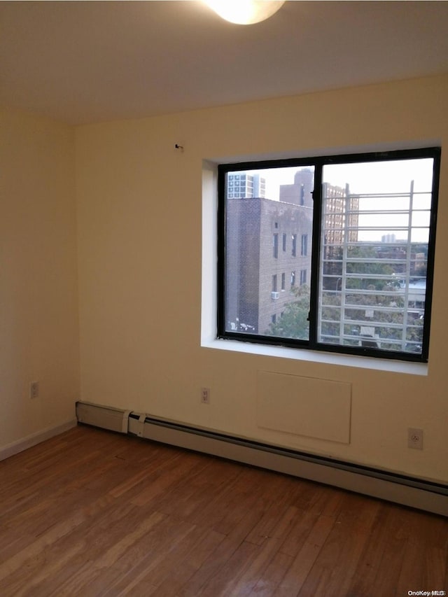 43-20 Union St Unit 6D, Flushing, NY 11355 - empty room featuring wood finished floors, a baseboard radiator, and a city view