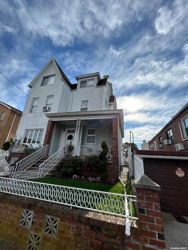 view of front of home featuring a garage, covered porch, and an outdoor structure