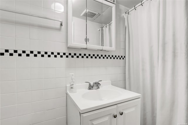 bathroom with decorative backsplash, a shower with curtain, vanity, and tile walls