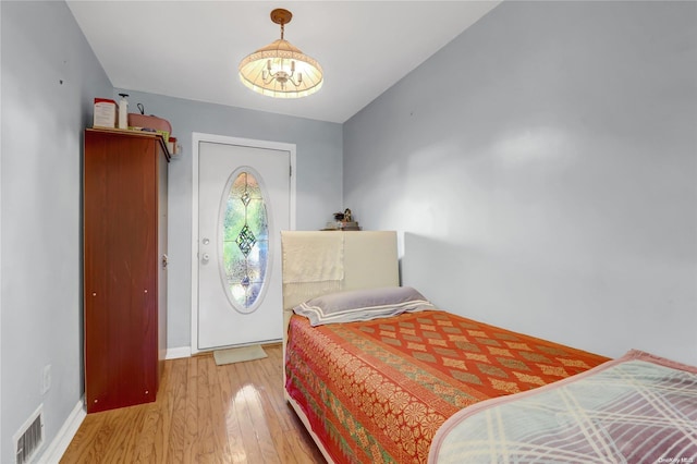 bedroom featuring a notable chandelier, wood-type flooring, and lofted ceiling