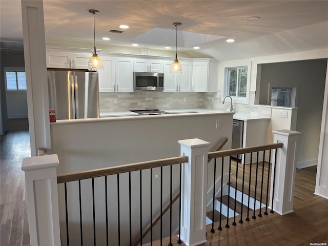 kitchen featuring appliances with stainless steel finishes, dark hardwood / wood-style flooring, backsplash, pendant lighting, and white cabinets