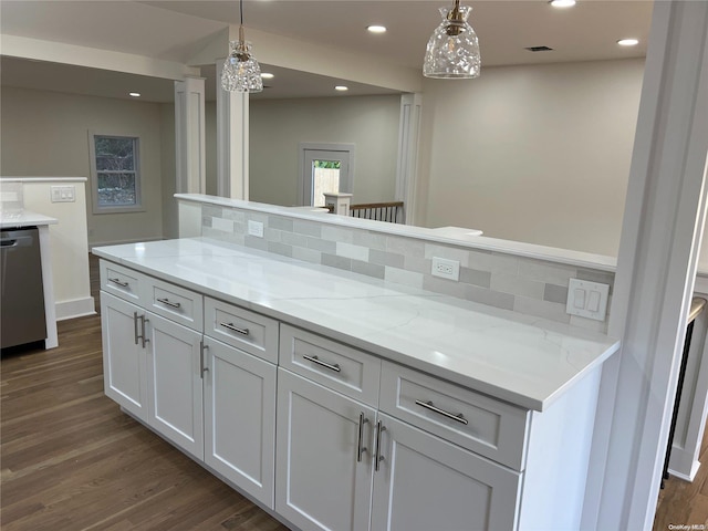 kitchen featuring decorative backsplash, dishwasher, dark hardwood / wood-style floors, white cabinetry, and hanging light fixtures