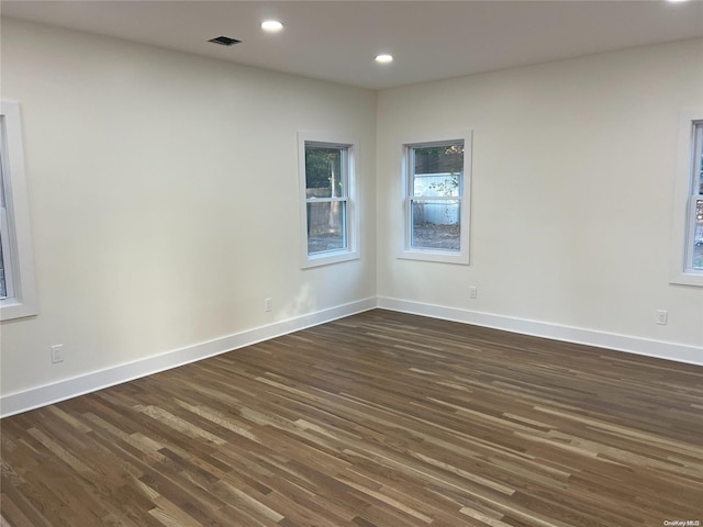 unfurnished room with dark hardwood / wood-style flooring