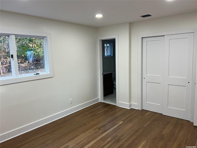 unfurnished bedroom featuring a closet and dark hardwood / wood-style floors