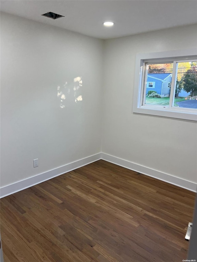 empty room with dark hardwood / wood-style flooring