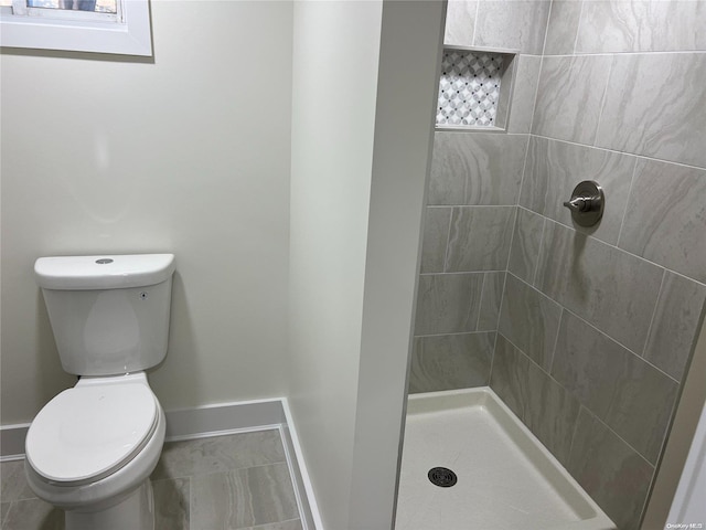 bathroom featuring toilet and tiled shower