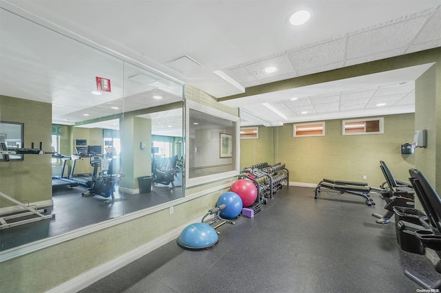 workout area featuring a paneled ceiling and a wall mounted air conditioner