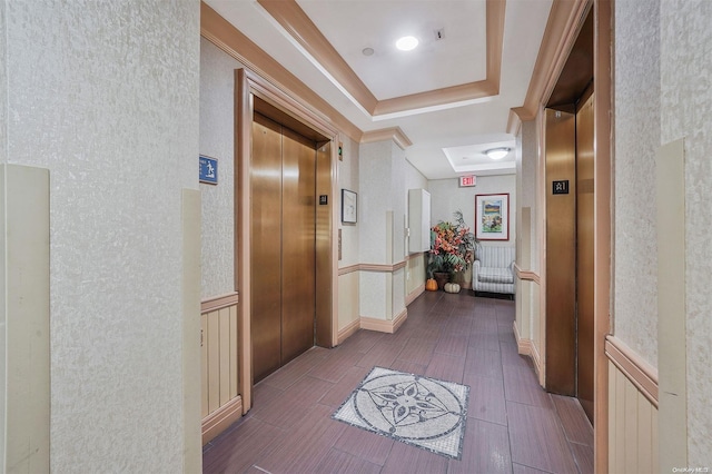 hall featuring a raised ceiling, elevator, and dark hardwood / wood-style flooring