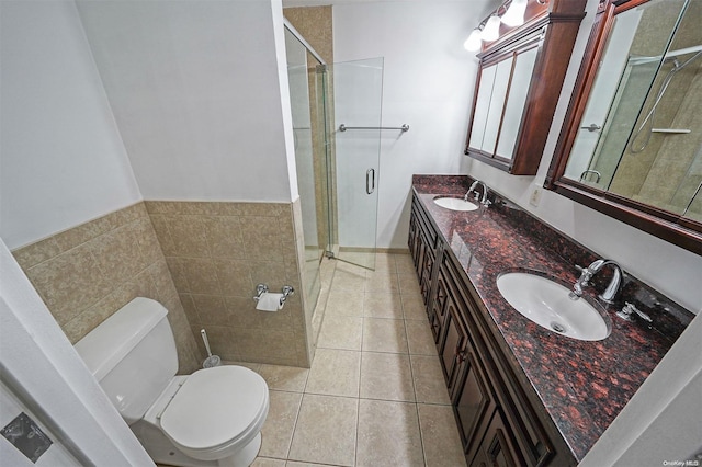 bathroom with tile patterned floors, vanity, an enclosed shower, and toilet