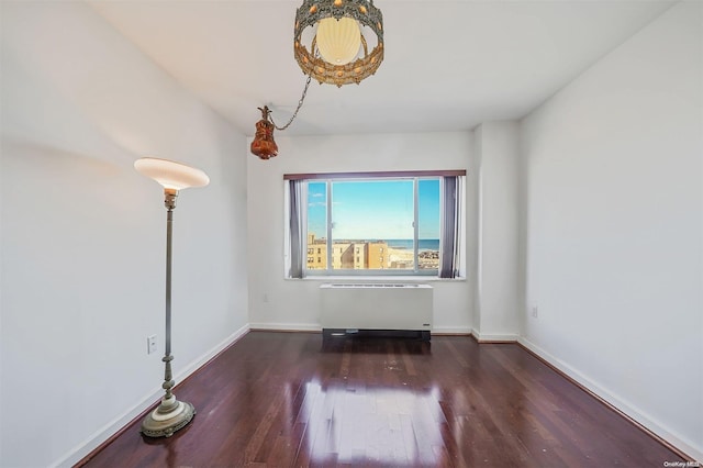 unfurnished room with radiator heating unit and dark wood-type flooring