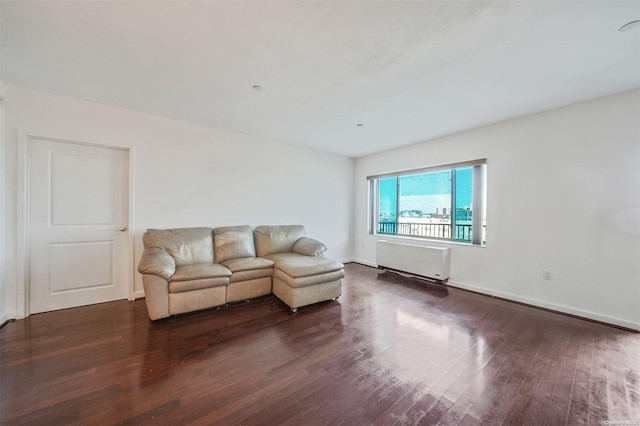 unfurnished living room with radiator heating unit and dark hardwood / wood-style flooring