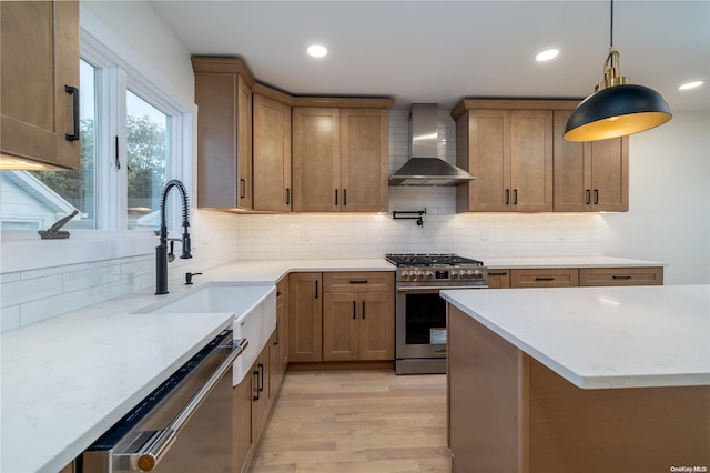 kitchen with sink, wall chimney range hood, light hardwood / wood-style flooring, backsplash, and appliances with stainless steel finishes