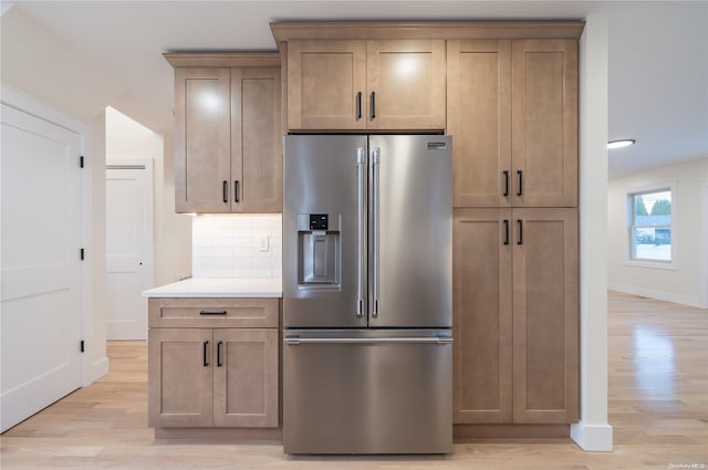 kitchen with backsplash, light hardwood / wood-style flooring, and stainless steel refrigerator with ice dispenser