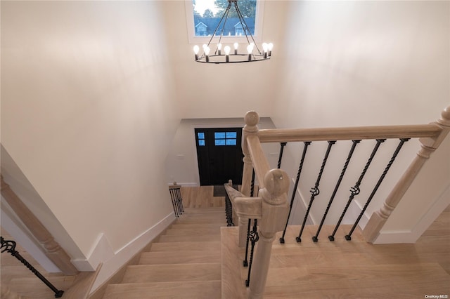 stairs featuring a chandelier and hardwood / wood-style flooring