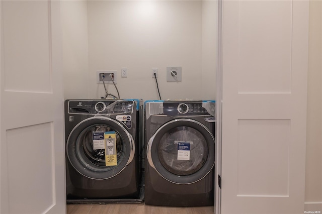 washroom featuring washer and clothes dryer and light wood-type flooring