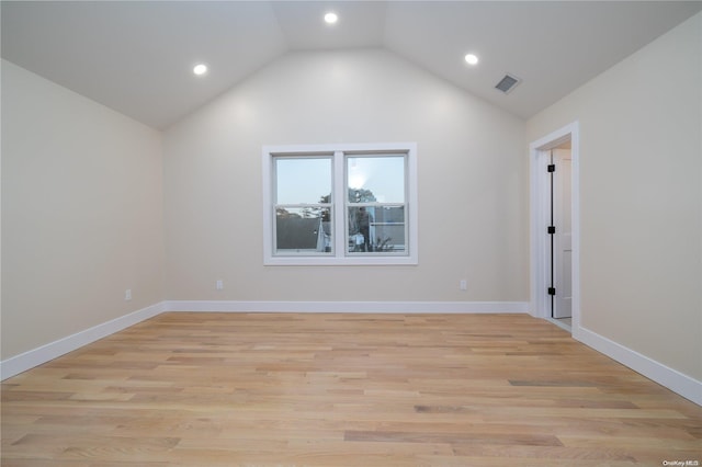 empty room featuring light hardwood / wood-style floors and vaulted ceiling