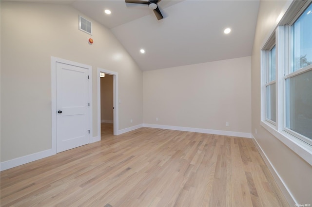 empty room with ceiling fan, high vaulted ceiling, and light hardwood / wood-style flooring