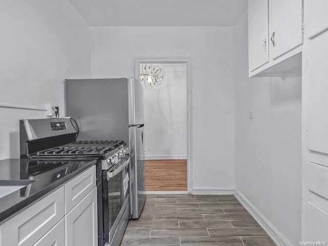 kitchen with wood-type flooring, gas stove, and white cabinetry